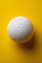 A white golf ball on a yellow background with some sort of pattern, AI Royalty Free Stock Photo