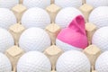 White golf balls in the box for eggs. Golf ball with funny cap. Royalty Free Stock Photo