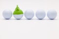 White golf balls with funny cap on the white background. Royalty Free Stock Photo