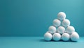 White golf balls stacked in a pyramid shape on a teal surface. The clean arrangement suggests order precision and focused Royalty Free Stock Photo