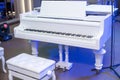 white grand piano and bench in the stage Royalty Free Stock Photo