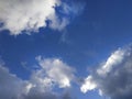 White and gray fluffy clouds illuminated by the sun on a blue sky background Royalty Free Stock Photo