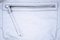 White gray leather bag purse and open zipper binding together two layers of gray fabric textile under magnification Royalty Free Stock Photo