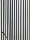 White gray painted corrugated zinc metallic sheet board fence texture pattern on house wall surface background. Detail backdrop