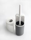 White and gray plastic toilet brush and roll of toilet paper on white background Royalty Free Stock Photo