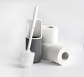 White and gray plastic toilet brush and roll of toilet paper on white background Royalty Free Stock Photo