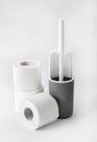 White and gray plastic toilet brush and roll of toilet paper on white background Royalty Free Stock Photo