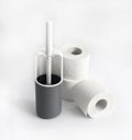 White and gray plastic toilet brush and roll of toilet paper on white background