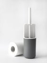 White and gray plastic toilet brush and roll of toilet paper on white background Royalty Free Stock Photo