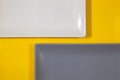 White and gray rectangle plates on the yellow wooden table Royalty Free Stock Photo