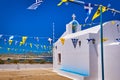 White Greek Orthodox chapel or church on top of hill against clear blue sky on sunny day, decorated Greek national Royalty Free Stock Photo