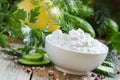 White greek sauce in white bowl with cucumber, lemon juice, herbs and spices on old wooden table, selective focus Royalty Free Stock Photo