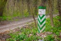 White green boundary post at a spring forest ground road Royalty Free Stock Photo