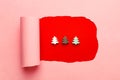 White green brown wooden decorative Christmas trees on crimson red background with torn out frame from pink backdrop. Paper art Royalty Free Stock Photo