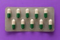 White and green capsules in medicine box. Pills over lavender ba Royalty Free Stock Photo