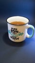 White and green ceramic mug with tea inside. Cup of tea with message