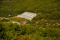 White green house on blue sky background. Plants crop in greenhouse. Closed rectangular greenhouse top view. Alanya, Turkey