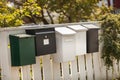 White and green mailboxes on a wooden white fence Royalty Free Stock Photo