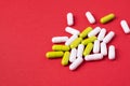 White and green pills capsules on red background Royalty Free Stock Photo