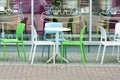 White and green plastic tables and chairs of a cafe