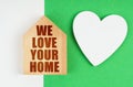 On a white-green surface, a heart and a house with the inscription - We love your home Royalty Free Stock Photo