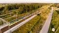 White and green train approaching small village station.