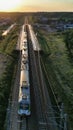 White and green train leaving small village station.