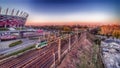 White and green train passing through next to National Stadium in Warsaw.