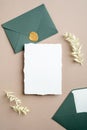White and green wedding stationery set. Blank greeting card, craft envelope with wax seal stamp, dried flowers.