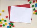 White greeting card template mockup with a red envelope on a creamy canvas background