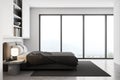 White and grey bedroom, bed with linens and bookshelf near window Royalty Free Stock Photo