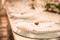 WHITE GROOM AND BRIDE WEDDING TABLE AT IMPRESSIVE COLOURFUL VENUE WITH BEAUTIFUL GREEN FLORAL DECORATION, WINE GLASSES, CRYSTAL PL Royalty Free Stock Photo