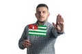 White guy holding a flag of Abkhazia and with a serious face shows a hand stop sign isolated on a white background