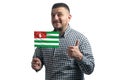 White guy holding a flag of Abkhazia and shows the class by hand isolated on a white background. Like for Abkhazia