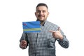 White guy holding a flag of Aruba and points the finger of the other hand at the flag isolated on a white background