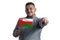 White guy holding a flag of Oman and points forward in front of him isolated on a white background