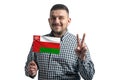 White guy holding a flag of Oman and shows two fingers isolated on a white background