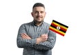 White guy holding a flag of Uganda smiling confident with crossed arms isolated on a white background