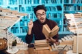 White guy surrounded by books in library. Student is emotionally reading book. Royalty Free Stock Photo