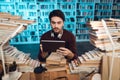 White guy surrounded by books in library. Student is using tablet. Royalty Free Stock Photo