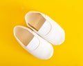 White gym shoes for children on a yellow background. Concepts for comfortable and light indoor shoes and sports, ballet shoes