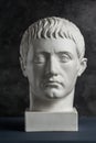 Gypsum copy of ancient statue Germanicus head on dark textured background. Plaster sculpture man face.