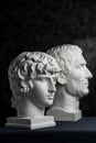 Gypsum copy of ancient statue Augustus and Antinous head on dark textured background. Plaster sculpture mans face. Royalty Free Stock Photo