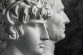 Gypsum copy of ancient statue Augustus and Antinous head on dark textured background. Plaster sculpture mans face. Royalty Free Stock Photo