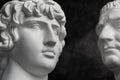 Gypsum copy of ancient statue Augustus and Antinous head on dark textured background. Plaster sculpture mans face. Royalty Free Stock Photo