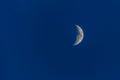 White half-moon on dark blue sky at night. Royalty Free Stock Photo