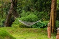 White hammock hanging between trees above the lawn In the middle of the garden