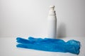 A white hand disinfection spray bottle with a blue nitril hand glove. Royalty Free Stock Photo