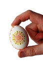 White hand painted and decorated easter egg held in right hand of small boy, white background