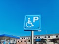 White Handicapped Parking Sign on Blue Label Against Clear Blue Sky Royalty Free Stock Photo